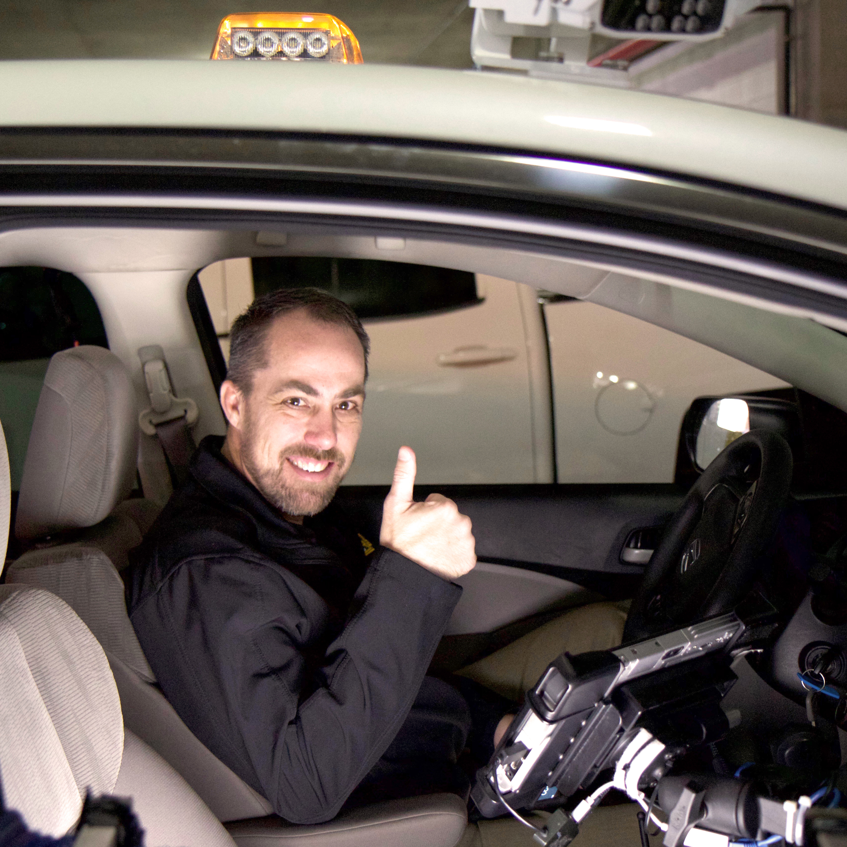 Baylor parking director giving thumbs up inside vehicle