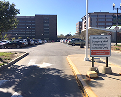 Hospital surface parking lot filled with cars and a barrier gate